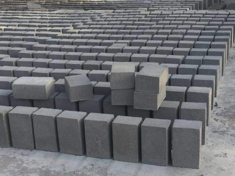 Thousands of solid grey cement bricks stood in rows across an open yard.